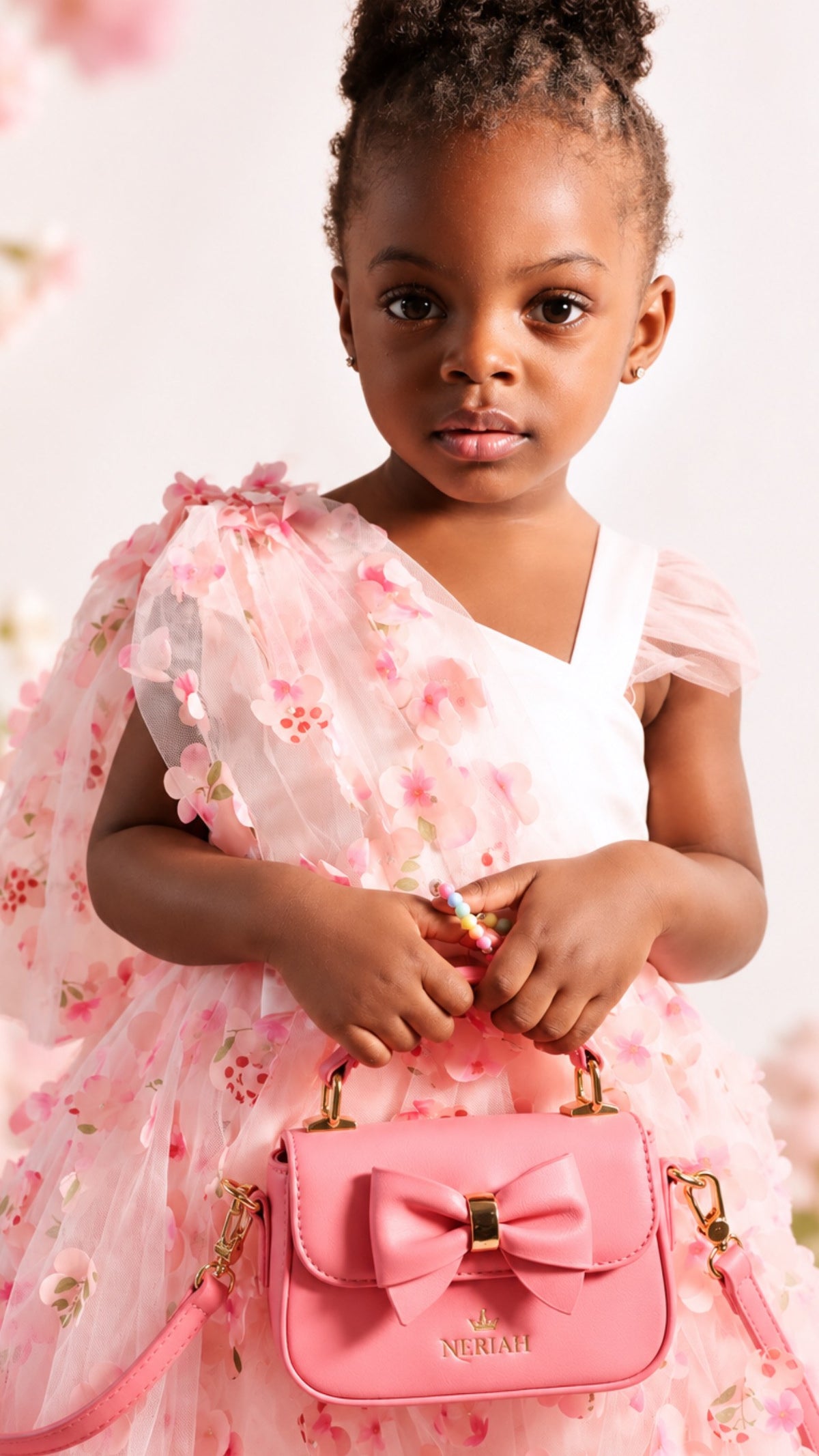 Girl holding Blush Pink NERIAH Bow Bag by the top handle